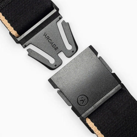 Close-up of a black woven strap with matte black metal buckles, one buckle showing the debossed brand name ARCADE.