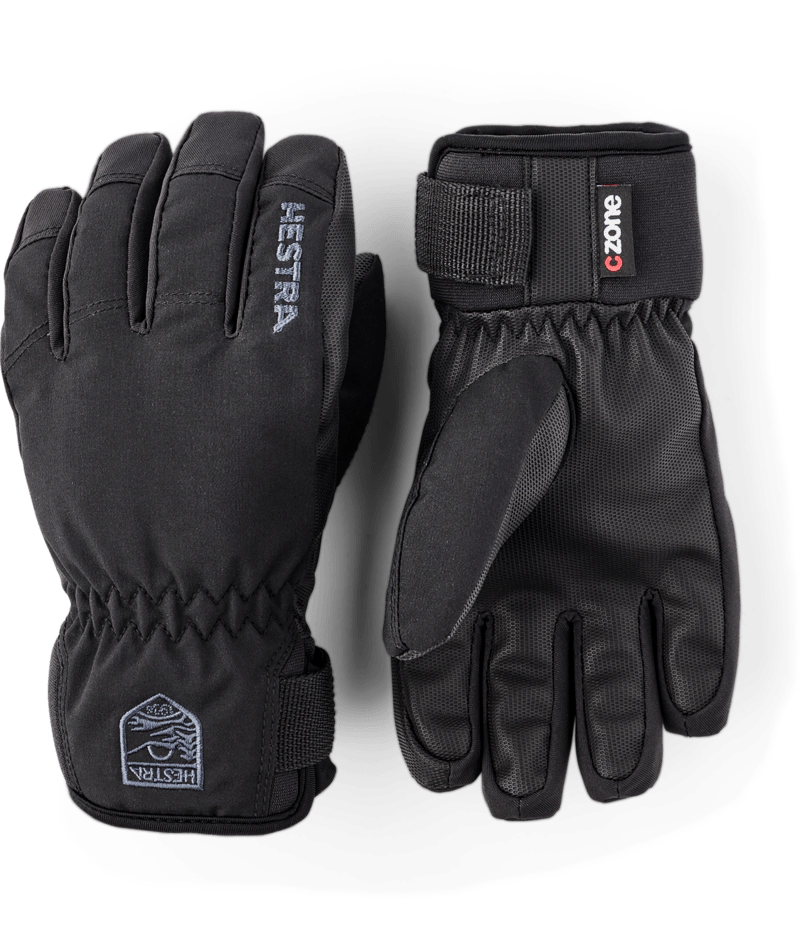 Hestra Ferox junior gloves in black with a C-Zone label and a wrist strap, a pair showing the back and the palm. Come in to Willi's Ski and Board.