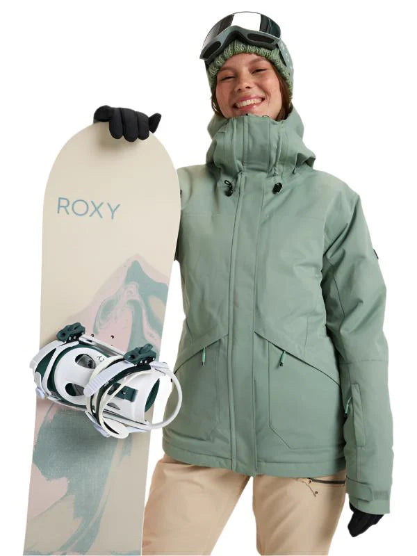 Roxy Illumine women's jacket in sage green, front view on a model holding a Roxy snowboard and wearing goggles on a beanie.